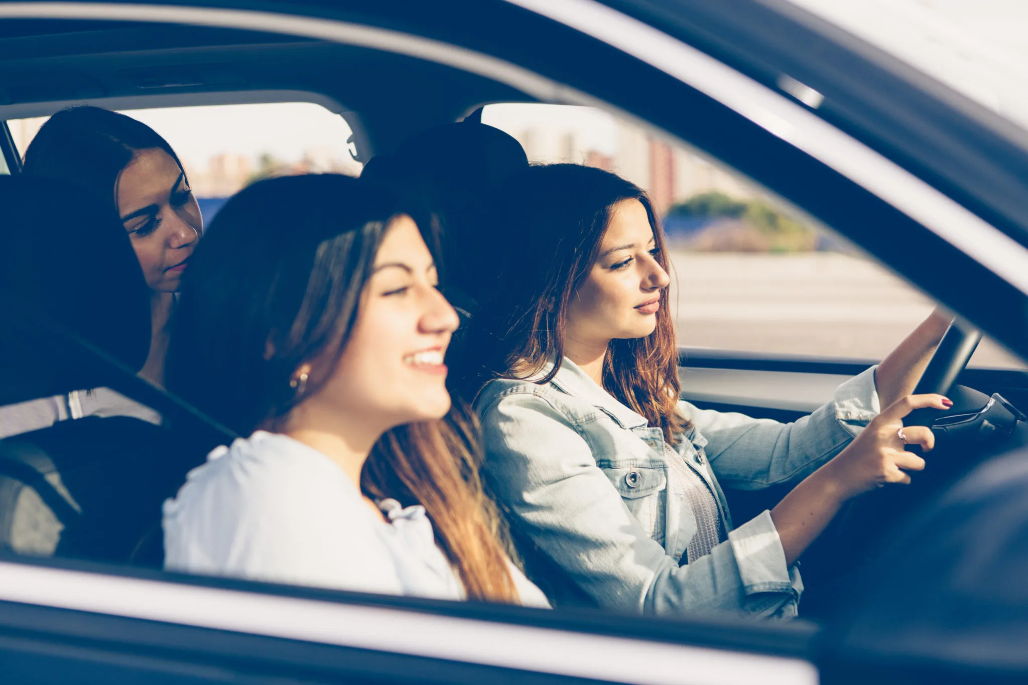 Girl is driving a car with her girls friends